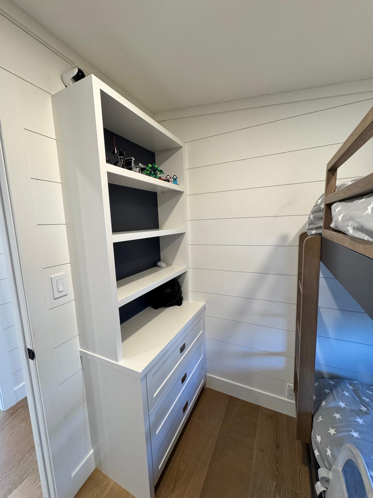 Custom built-in shelving and dresser in bunk room