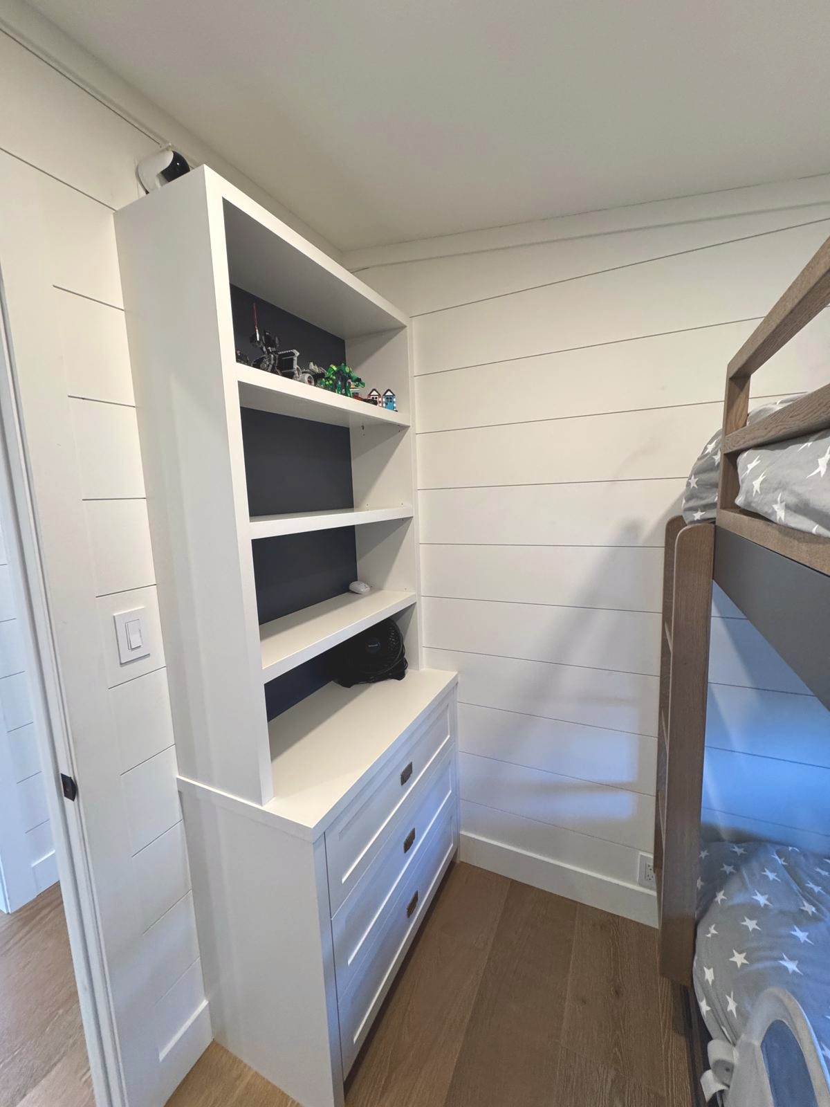 Custom built-in shelving and dresser in bunk room