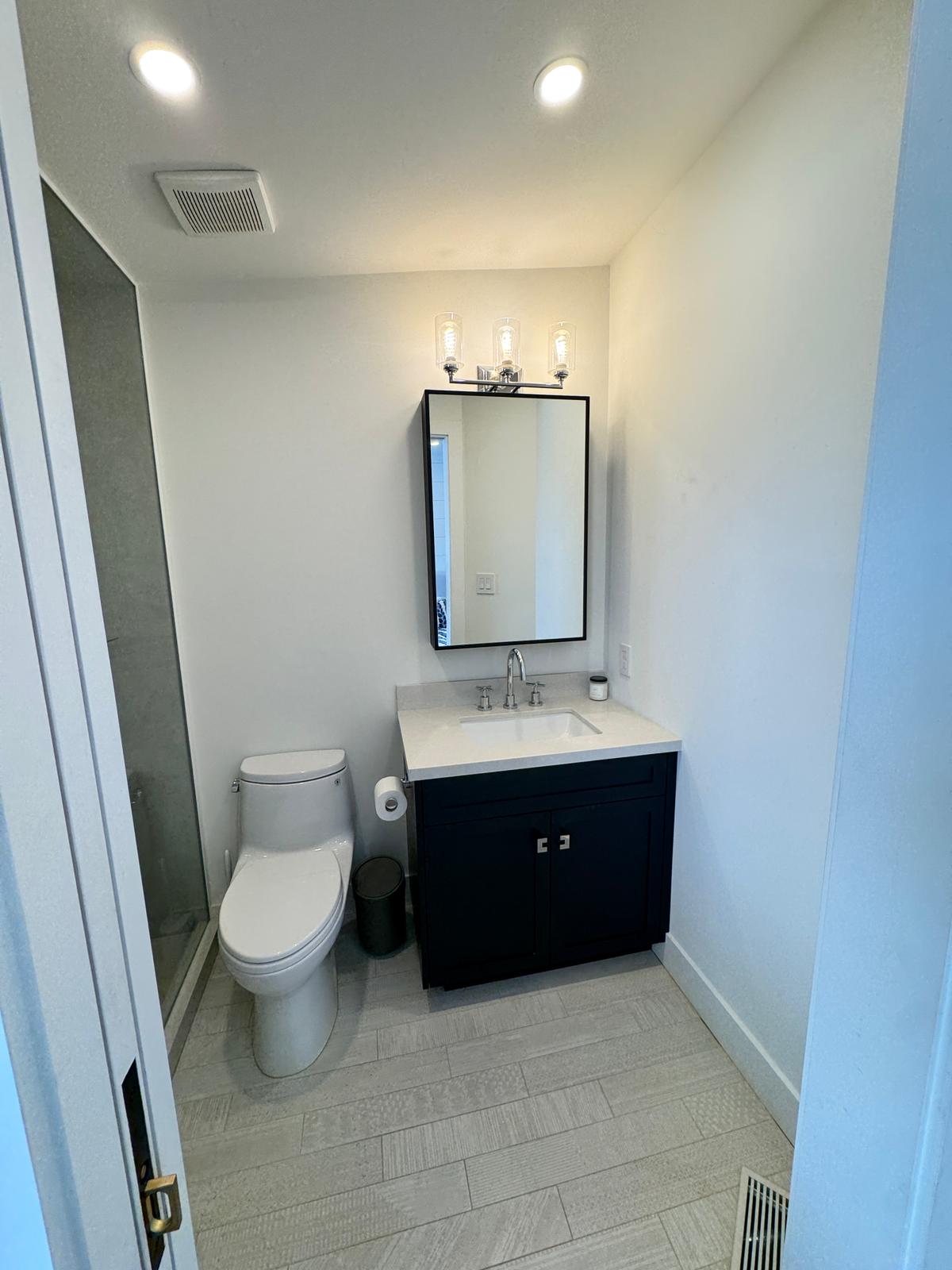 Ensuite powder bath with navy custom vanity