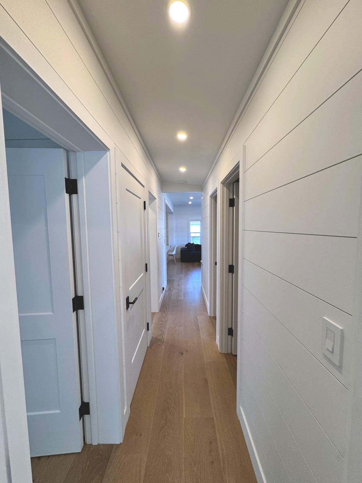 Hallway with shiplap walls and wide plank hardwood