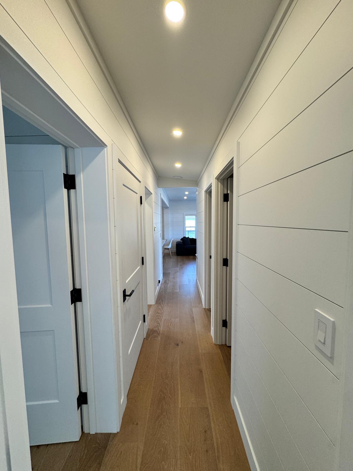 Hallway with shiplap walls and wide plank hardwood