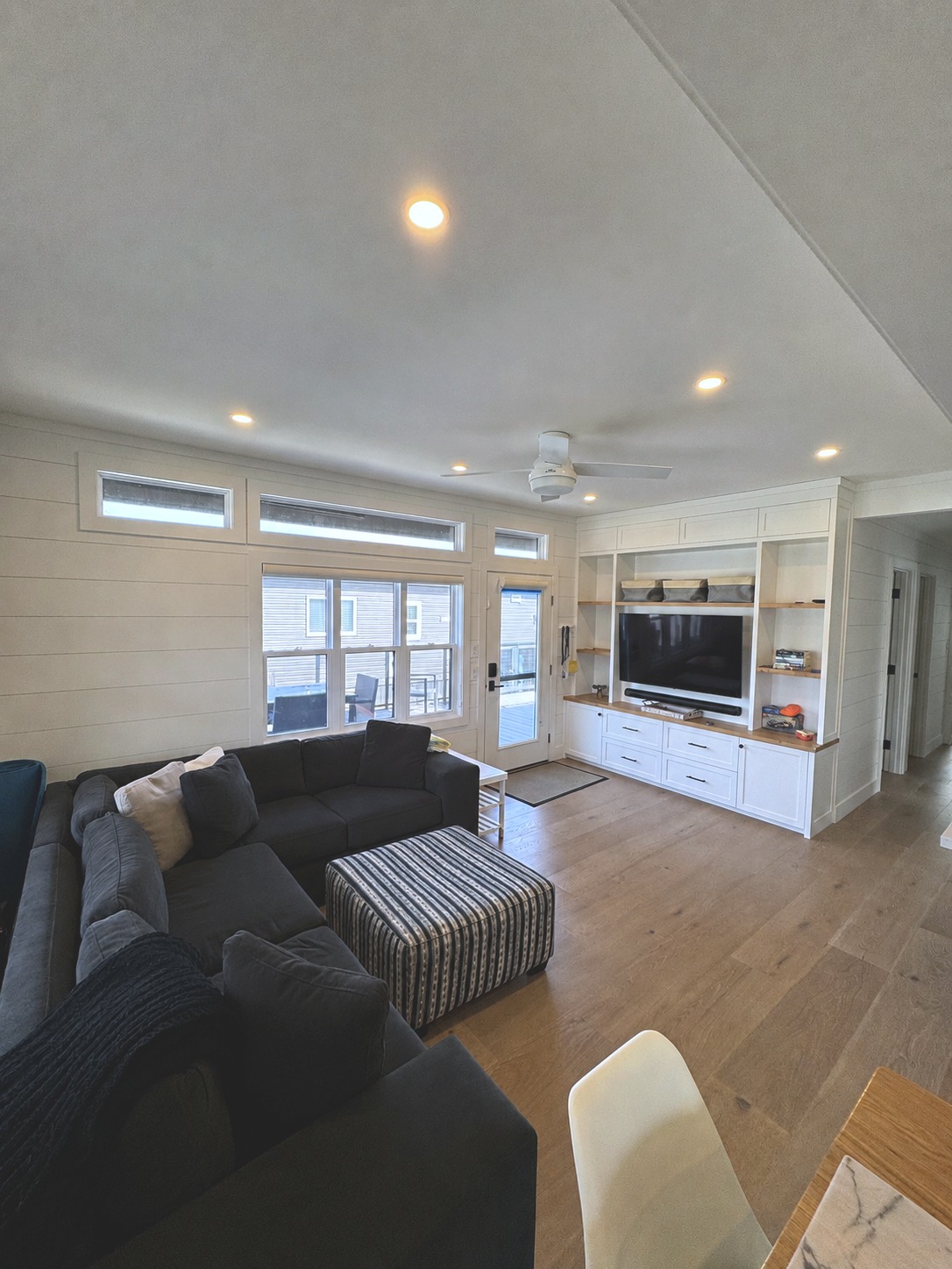 Open-concept living room with custom built-ins and shiplap walls