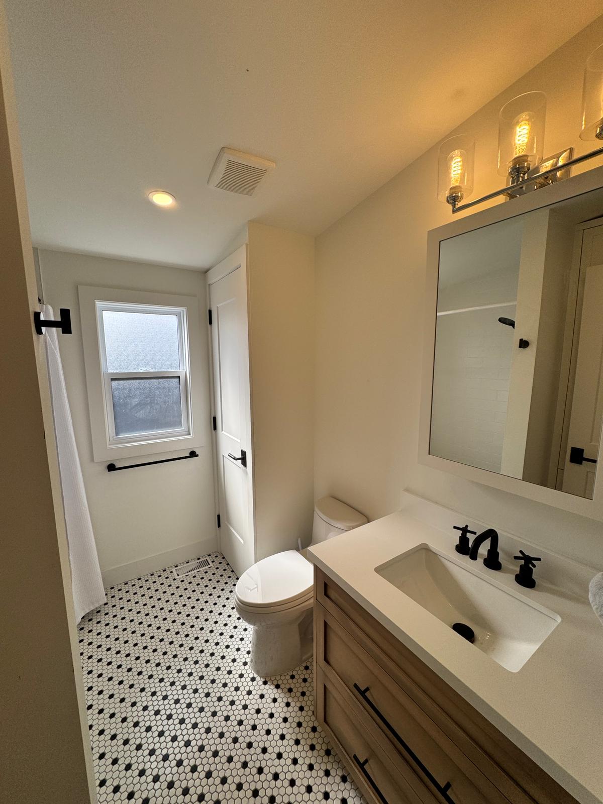Main bathroom with mosaic tile floor and custom vanity