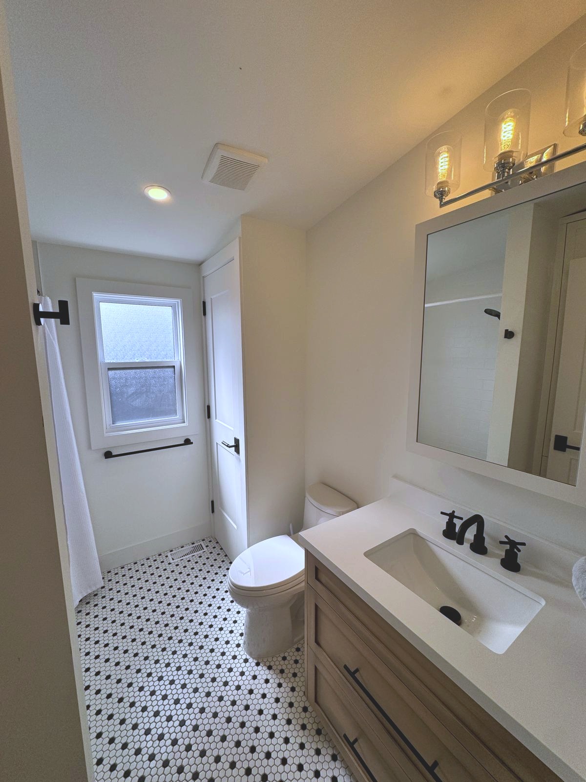 Main bathroom with mosaic tile floor and custom vanity