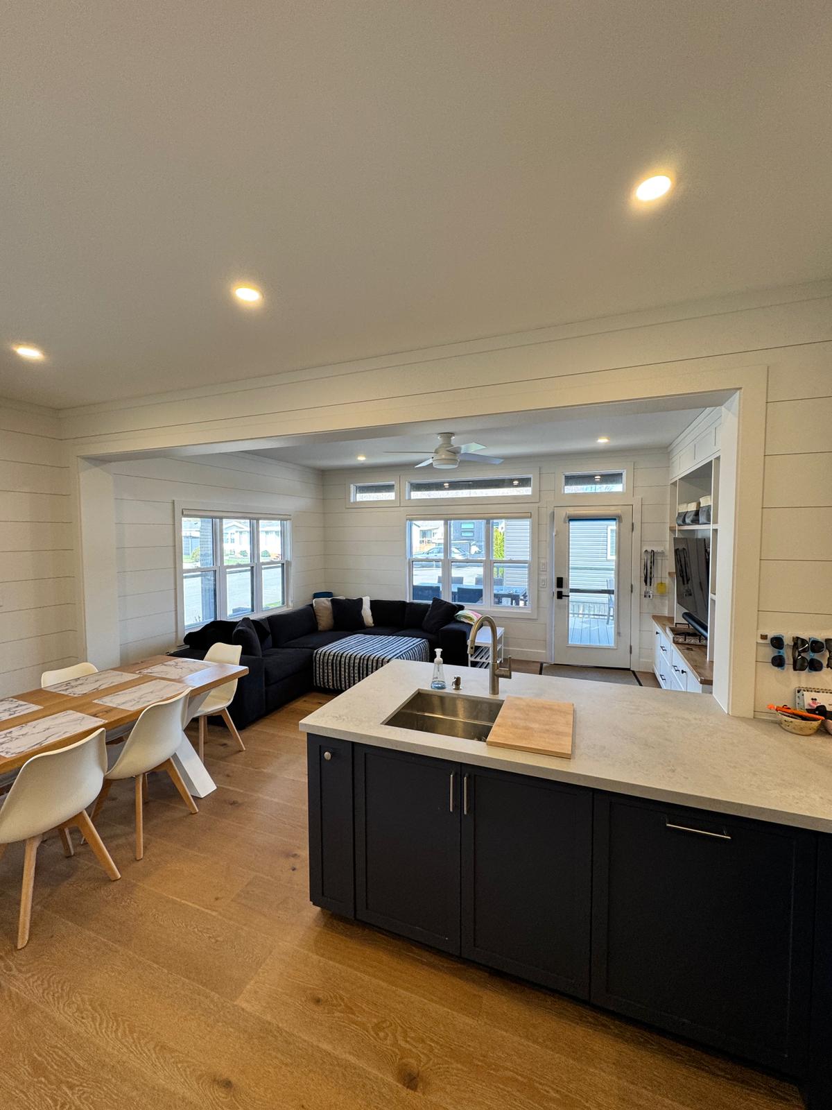 Open-concept living, dining and kitchen with navy island and walkout to wrap-around deck